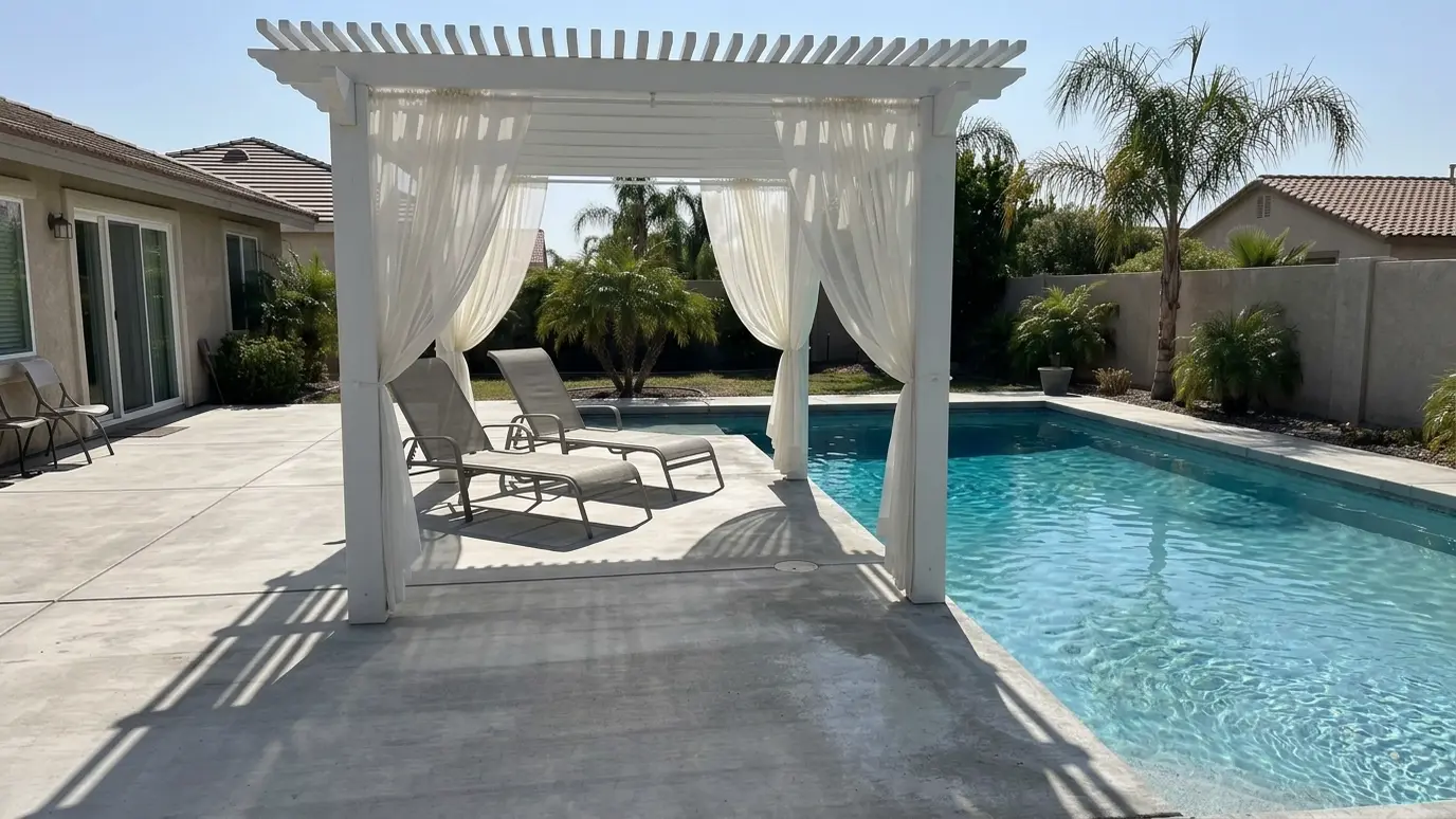 After: Pool deck gets a shaded lounge | Music City Pergola After: a pool deck with a white pergola with sheer curtains over the lounge chairs